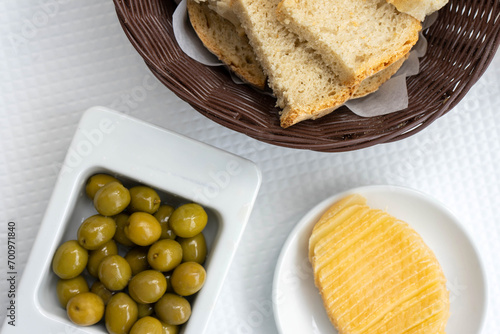 Traditional Alentejo cuisine: green olives, bread, and cheese on a rustic table in a local restaurant.