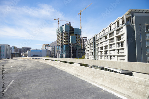 City, road and CBD of Cape Town construction, industrial architecture or buildings in urban suburb. Asphalt street and concrete infrastructure with blue sky, cranes and empty bridge in South Africa