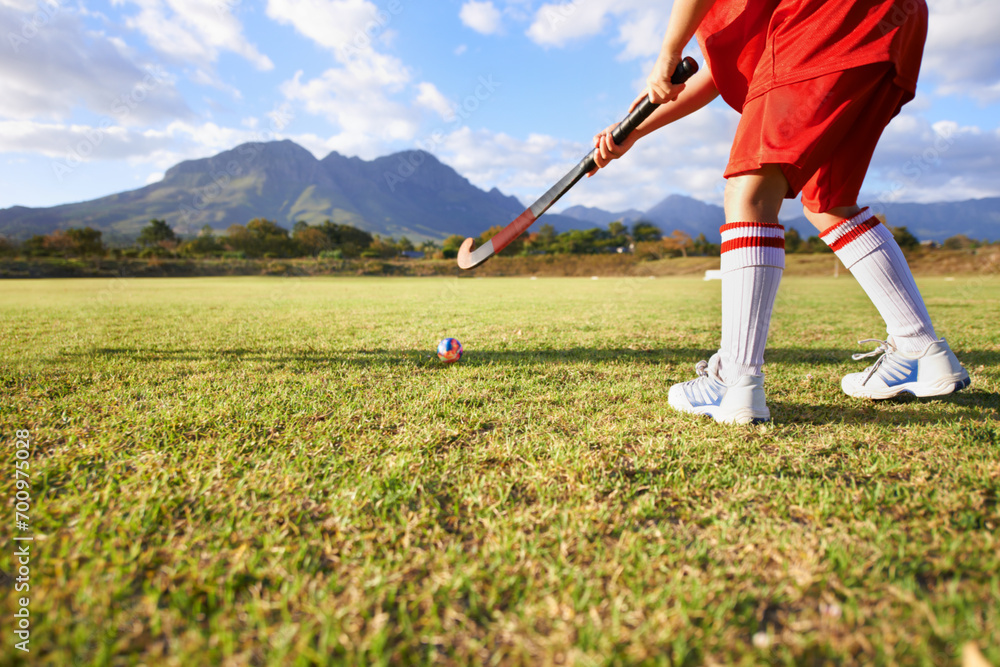 Fototapeta premium Person, green grass and playing hockey for game, outdoor match or sports in nature for practice. Closeup of child, kid or player enjoying competition with ball on field for fitness training outside