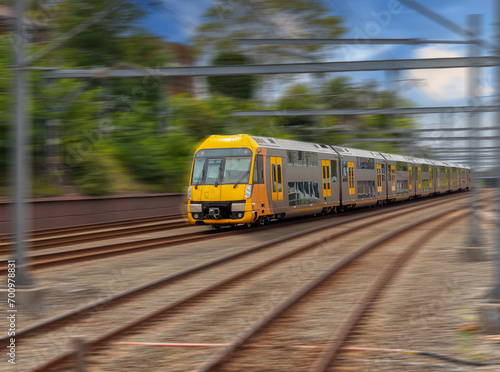 Commuter Train fast moving through a Station in Sydney NSW Australia locomotive electric light rail