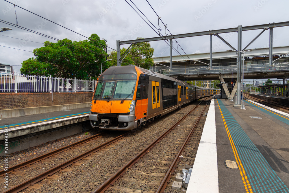 Commuter Train fast moving through a Station in Sydney NSW Australia locomotive electric light rail