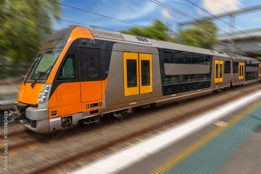 Naklejka premium Commuter Train fast moving through a Station in Sydney NSW Australia locomotive electric light rail