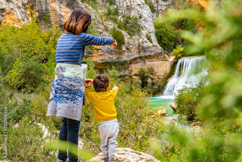 Woman and son walking on the path next to the waterfalls of the Vero River walkways in Alquezar. Pyrenees photo