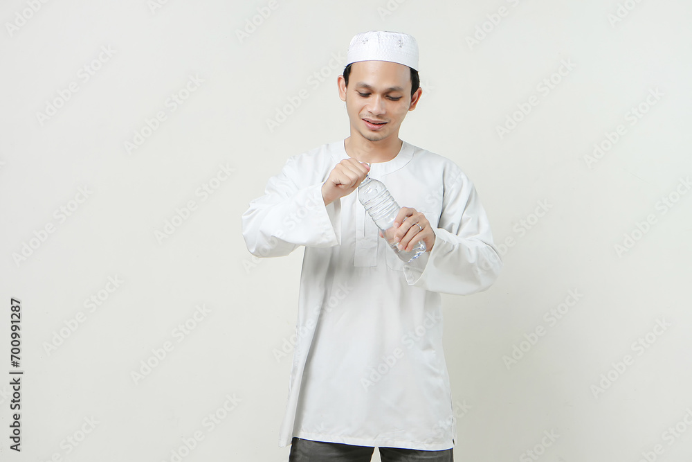 asian muslim man opening water bottle. People religious Islam lifestyle concept. celebration Ramadan and ied Mubarak. on isolated background.