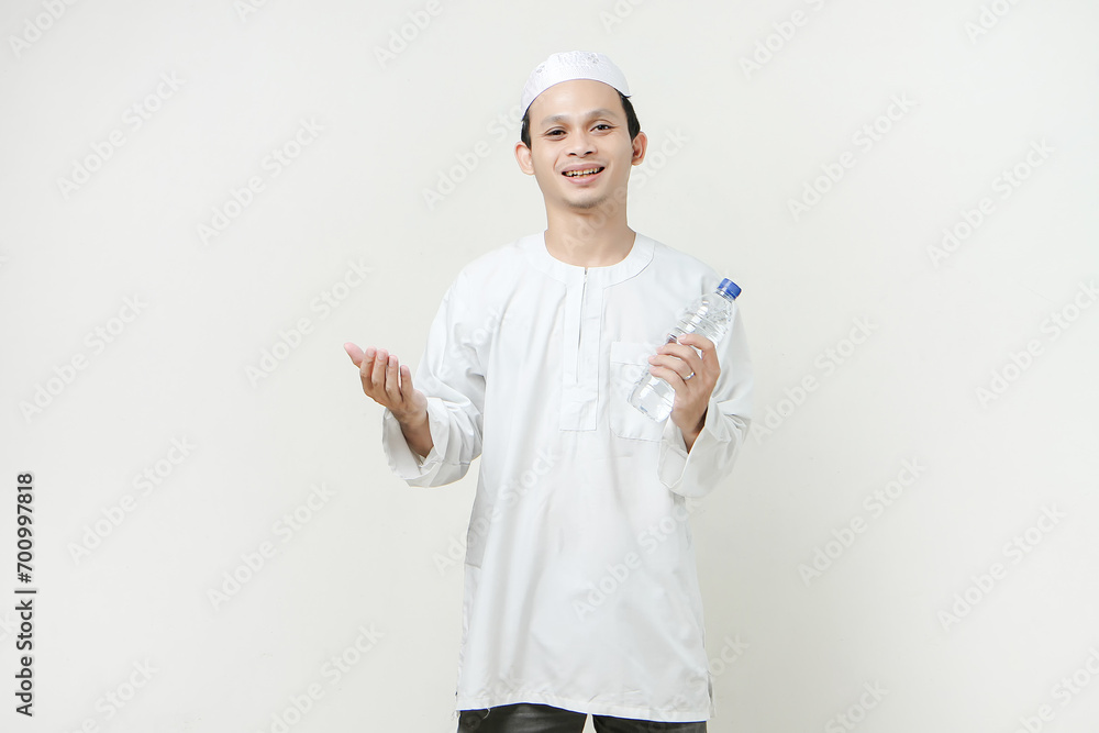 asian muslim man holding water bottle and make pray hand gesture. People religious Islam lifestyle concept. celebration Ramadan and ied Mubarak. on isolated background. asian muslim man holding water bottle and make pray hand gesture. People religious Islam lifestyle concept. celebration Ramadan and ied Mubarak. on isolated background.