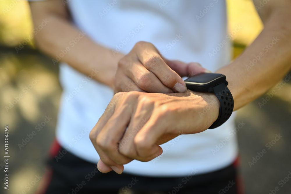 Closeup sporty senior man checking performance or heart rate pulse trace on smartwatch.