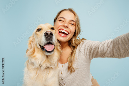 Close up young owner woman with her best friend retriever dog wear casual clothes do selfie shot on mobile cell phone wink isolated on plain pastel light blue background. Take care about pet concept. photo