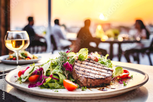 Abendliche Atmosphäre im Restaurant mit einem Steak auf Salat im Vordergrund 