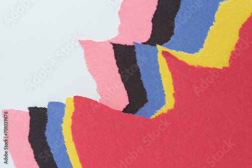 abstract torn construction paper landscape composed of layered sheets and ripped edges - red, yellow, blue, black, and pink jagged edges