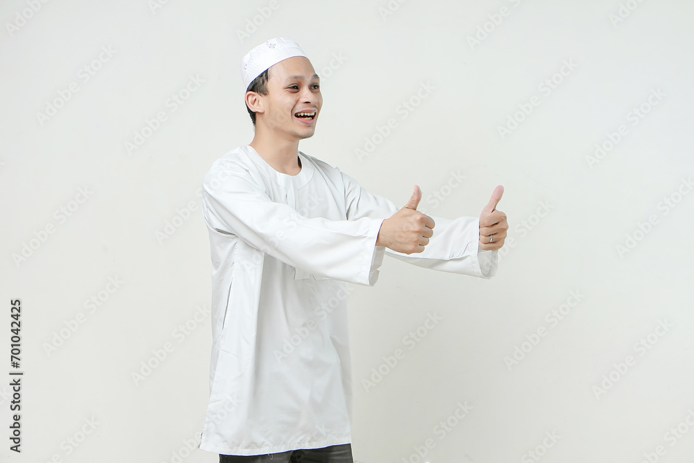 Asian Muslim give thumb up gesture on isolated background. People religious Islamic lifestyle concept Asian Muslim give thumb up gesture on isolated background. People religious Islamic lifestyle concept