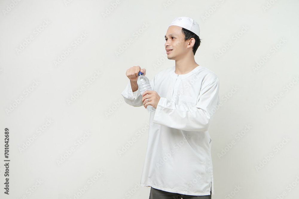 asian muslim man opening water bottle. People religious Islam lifestyle concept. celebration Ramadan and ied Mubarak. on isolated background. asian muslim man opening water bottle. People religious Islam lifestyle concept. celebration Ramadan and ied Mubarak. on isolated background.