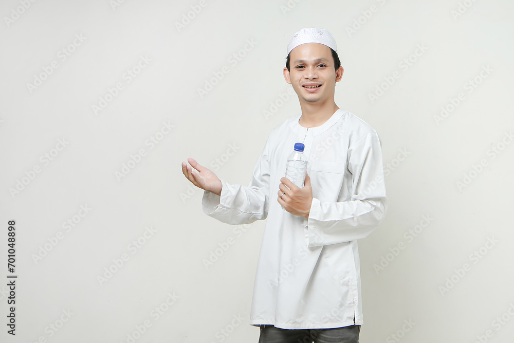 asian muslim man holding water bottle and make pray hand gesture. People religious Islam lifestyle concept. celebration Ramadan and ied Mubarak. on isolated background. asian muslim man holding water bottle and make pray hand gesture. People religious Islam lifestyle concept. celebration Ramadan and ied Mubarak. on isolated background.