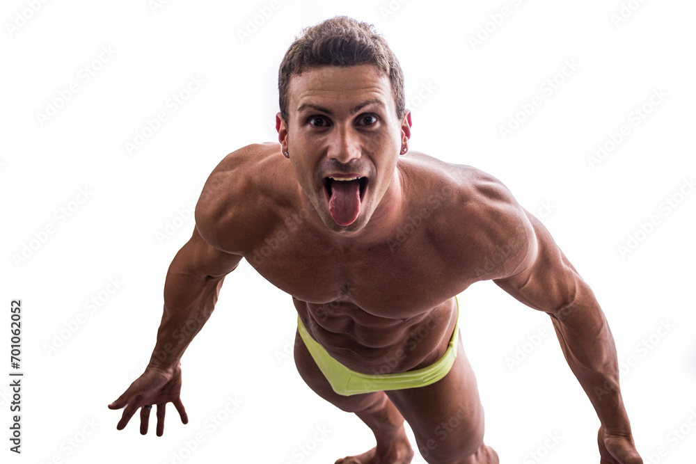 Shirtless muscular man shot from above, looking at camera, standing isolated in studio shot Shirtless muscular man shot from above, looking at camera, standing isolated in studio shot
