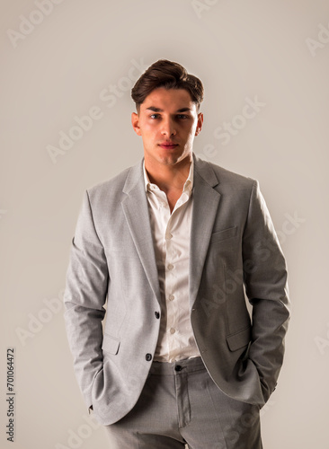 Attractive elegant young man with business suit, on white, looking at camera