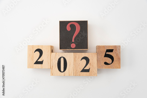 Number 2025 and question mark written on wooden blocks isolated on white background