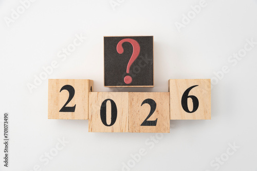Number 2026 and question mark written on wooden blocks isolated on white background