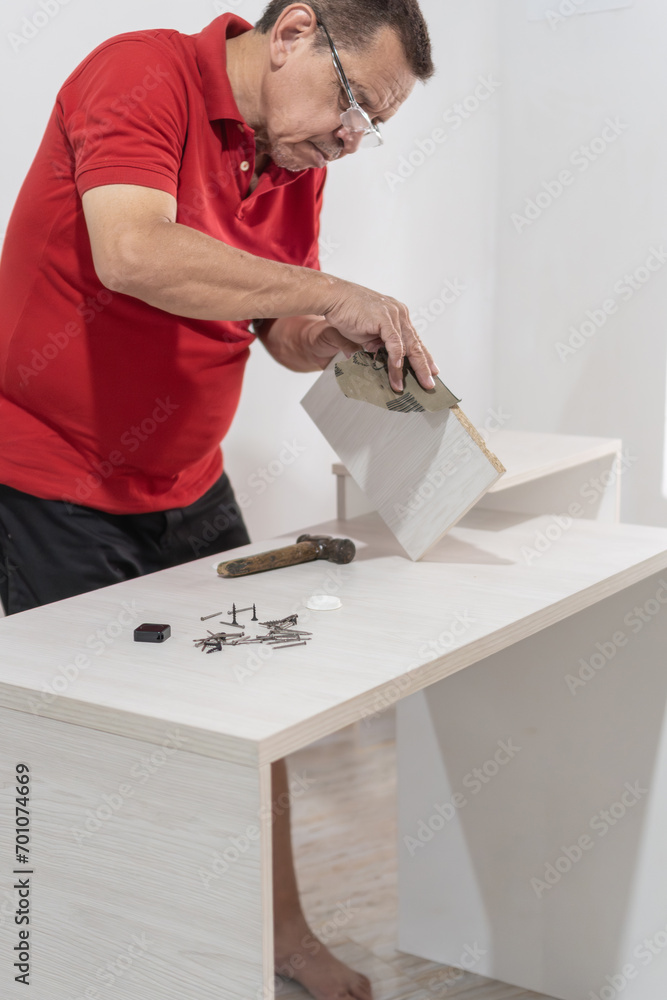 Man sanding a piece of furniture at home.