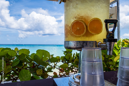 A fresh water dispenser with fruit on Paynes bay beach with a turquoise sea in the background along the caribbean coast (Barbados). photo