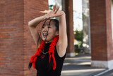 Portrait of asian woman with special hairstyle dancing in the street.