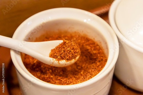 Red chili powder in a white cup for cooking