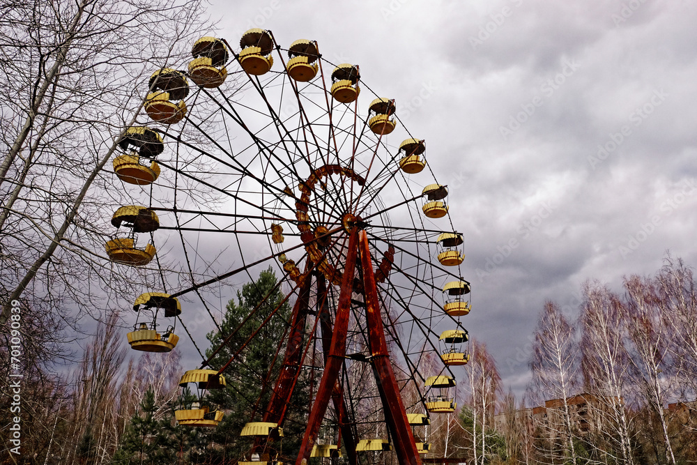 An old Ferris wheel with rusted structure and yellow seats. An old Ferris wheel with rusted structure and yellow seats.