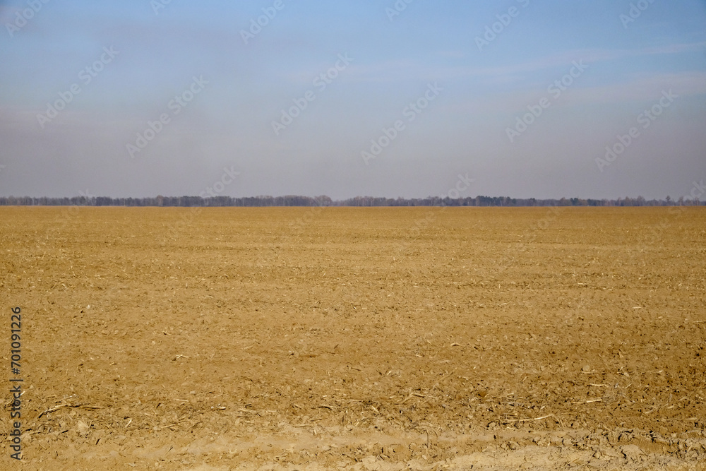 Plowed agricultural land ready for sowing, blue sky above. Plowed agricultural land ready for sowing, blue sky above.