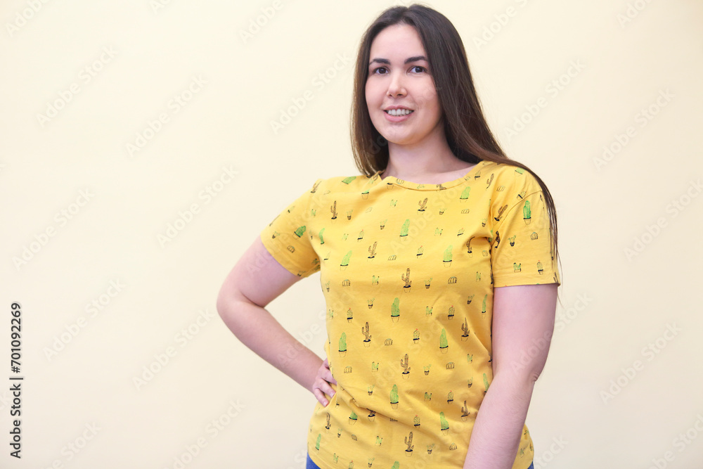 Obraz premium Beautiful plus size curly young brunette woman posing on yellow