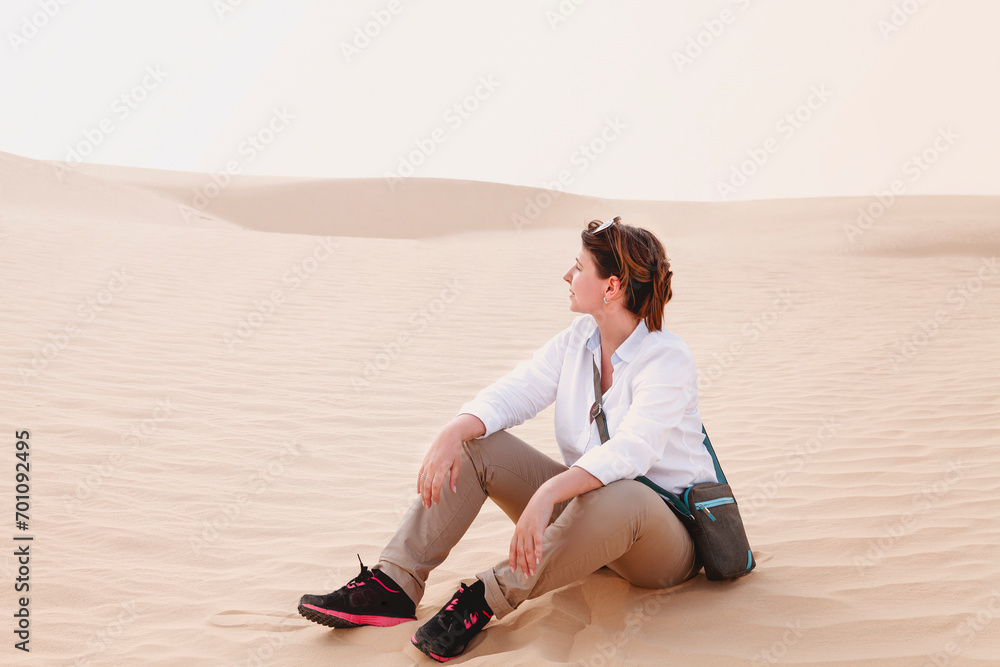 Calm woman sitting on sand