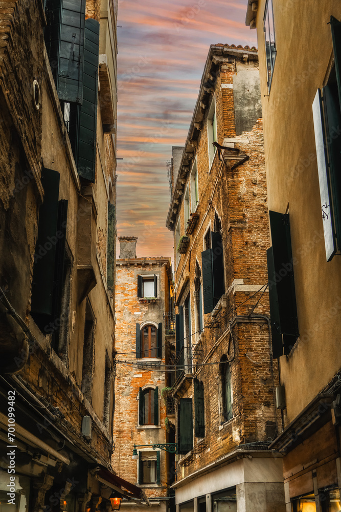 Facades of weathered buildings with windows on street of Venice city
