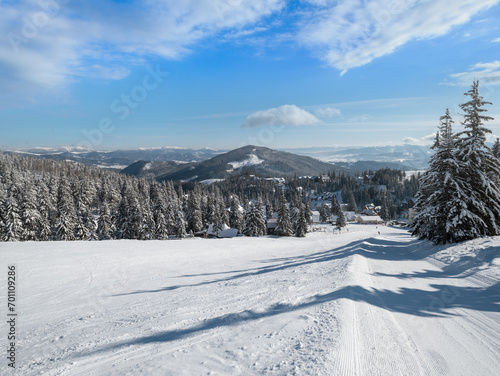 Snow covered mountain ski resort slope . Magnificent sunny day on picturesque alpine resort, Dragobrat, Ukraine, Carpathian Mountains. People unrecognizable. © wildman