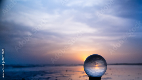 Crystal lens ball on a stand at the beach at sunrise in blues and violets. Glass photography ball reflecting the colors of the sunrise over North Padre Island National Seashore in Texas