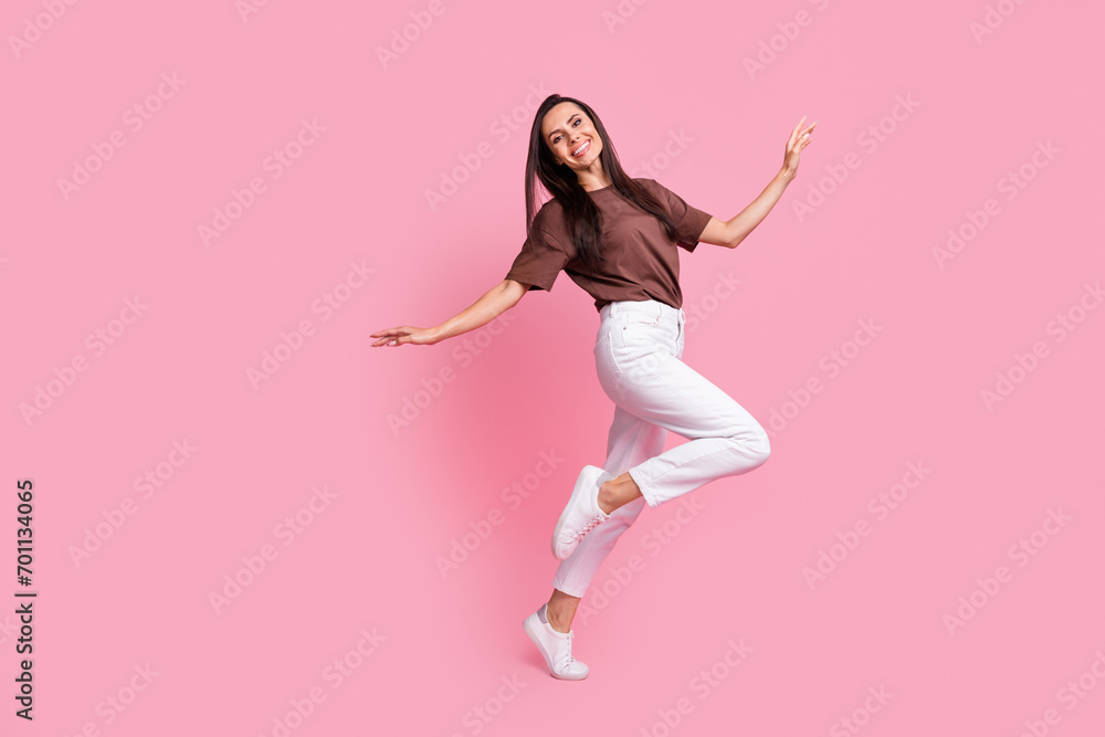 Full size profile portrait of carefree lovely girl dancing chill entertainment empty space isolated on pink color background