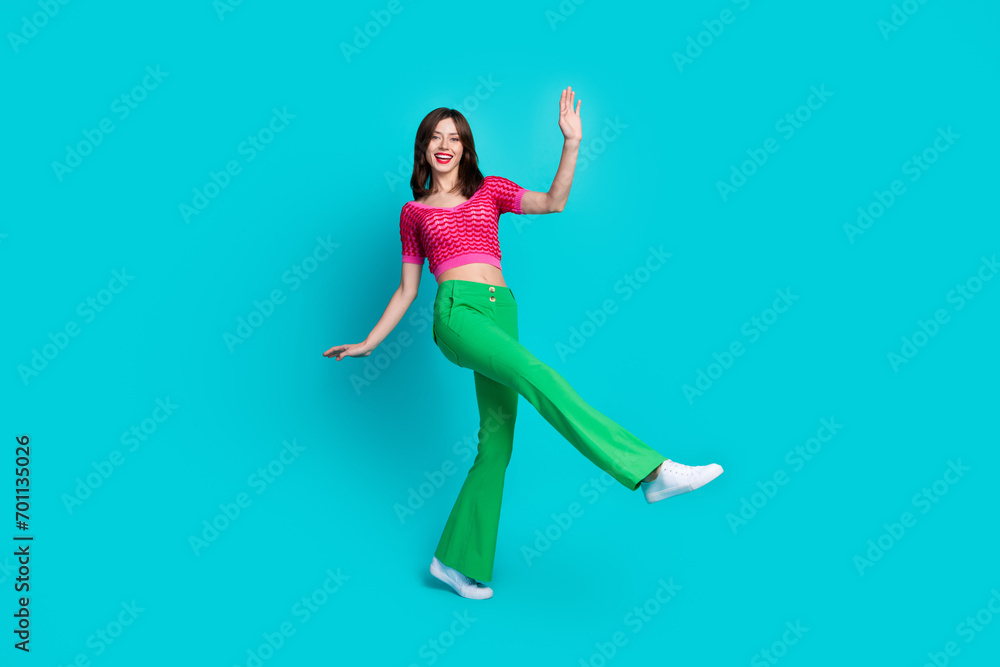 Full length photo of friendly optimistic woman dressed knitwear top green retro pants dancing have fun isolated on blue color background