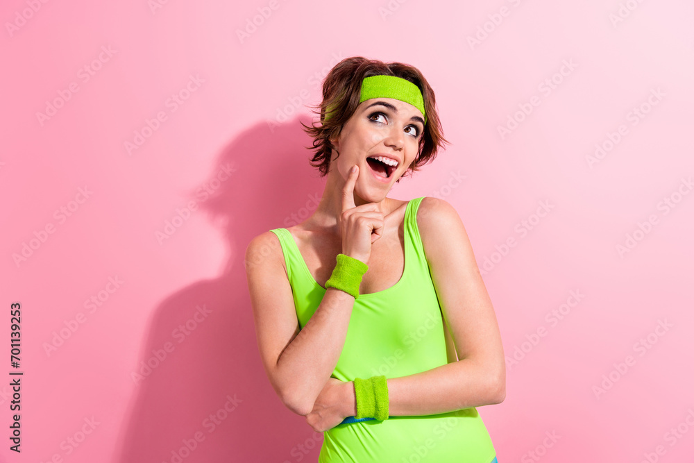 Photo of excited funky woman dressed neon sporty bodysuit finger cheek cheekbone looking empty space isolated pink color background Photo of excited funky woman dressed neon sporty bodysuit finger cheek cheekbone looking empty space isolated pink color background