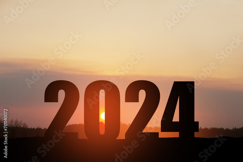 Silhouette 2024 with sunset sky at mountain and number like 2024 abstract background. Concept of start with strategy, win, plan, goal and objective target. photo
