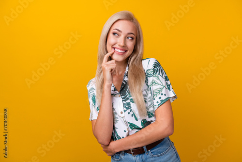 Photo of cunning tricky woman with straight hair dressed shirt look empty space finger on lips isolated on yellow color background