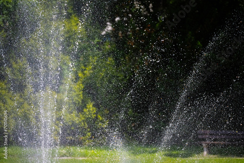 Fountain water drops with mature trees in the background