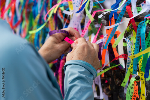 Stampa su tela Catholics and tourists are seen tying a souvenir ribbon on the iron railing of the Senhor do Bonfim church in the city of Salvador, Bahia