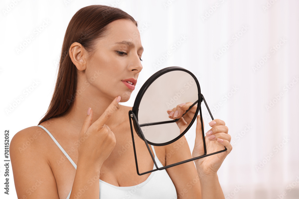 Woman with skin problem looking at mirror indoors Woman with skin problem looking at mirror indoors