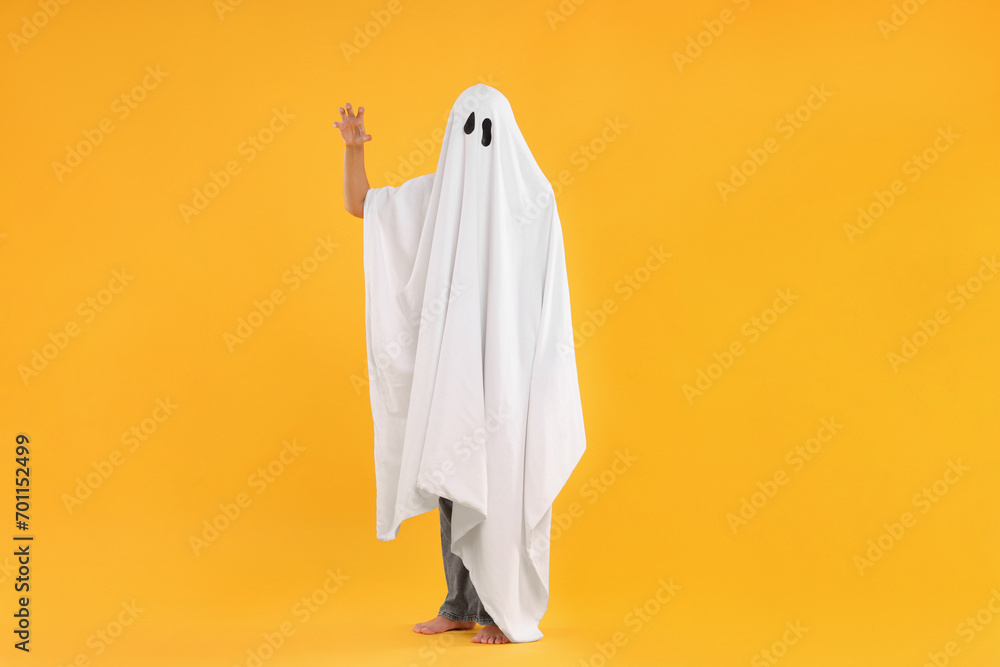 Woman in white ghost costume on yellow background. Halloween celebration Woman in white ghost costume on yellow background. Halloween celebration