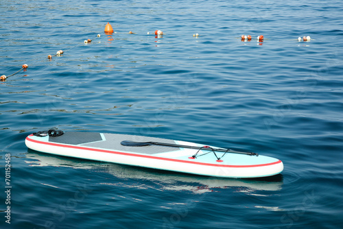 One SUP board with paddle on water in sea