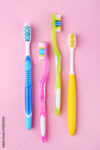 Many different toothbrushes on pink background  flat lay