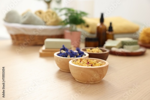 Bowls of dry flowers on light wooden table. Spa therapy