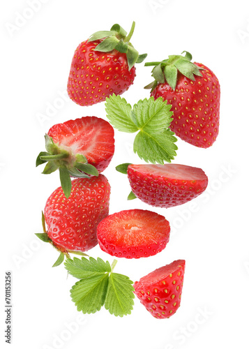 Fresh ripe strawberries and green leaves falling on white background
