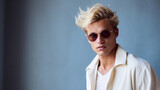Stylish young man poses in shirt and modern sunglasses. Mens accessories, optics. Studio portrait.