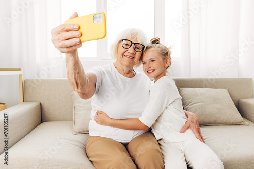Education hugging togetherness phone sofa smiling child bonding selfie family granddaughter grandmother