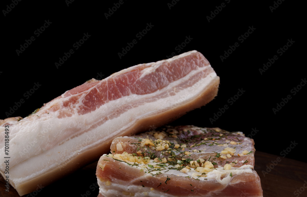 Appetizing salty lard with layers of meat. Salted lard with garlic and herbs. Appetizing salty lard with layers of meat. Salted lard with garlic and herbs.