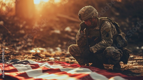 american soldier mourning and praying with the american flag in front of him photo
