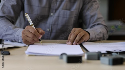 Businessman working on paperwork and stamping approvals, signing documents. photo
