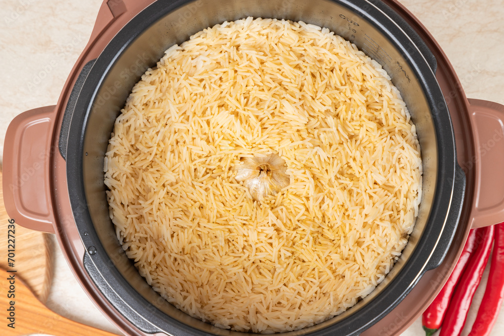 Just cooked pilaf with turkey, mutton, beef or pork, carrots, onions, garlic, pepper and raisin in the modern multicooker. A traditional dish of Asian cuisine. Just cooked pilaf with turkey, mutton, beef or pork, carrots, onions, garlic, pepper and raisin in the modern multicooker. A traditional dish of Asian cuisine.
